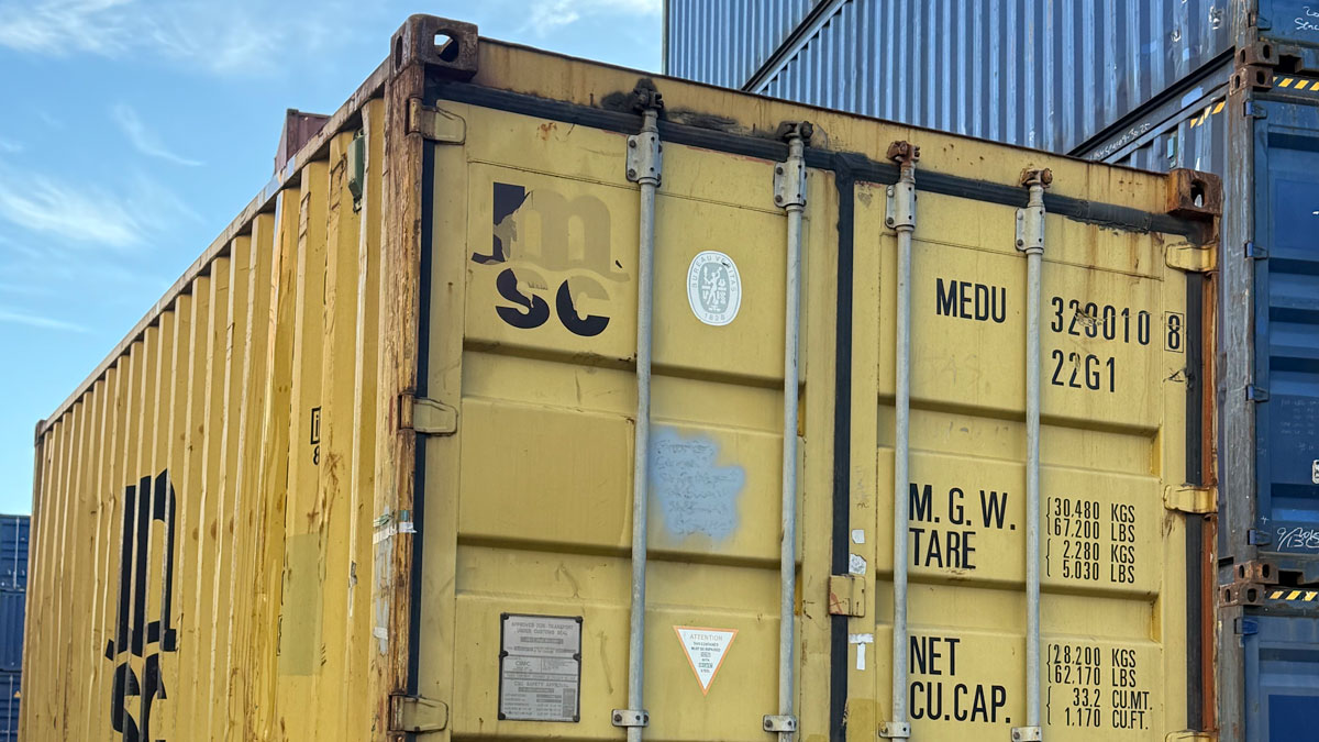 A shipping container with many shipping containers in the background.